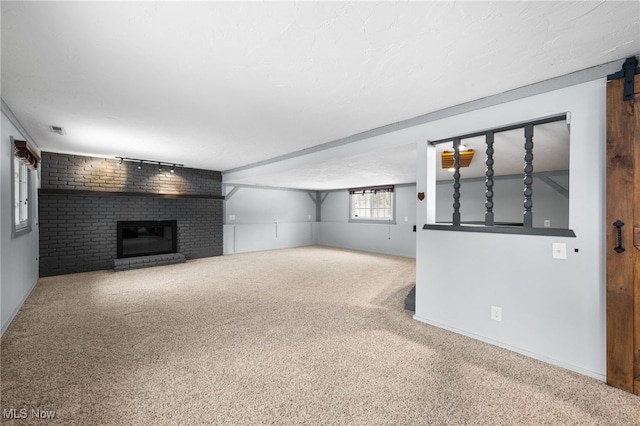 unfurnished living room featuring visible vents, a brick fireplace, baseboards, and carpet floors