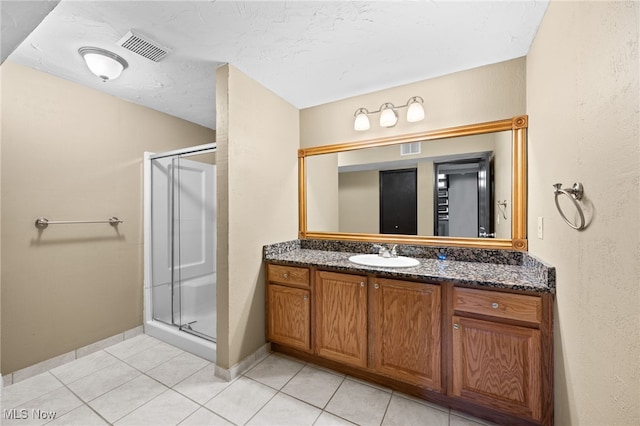 bathroom with vanity, tile patterned floors, visible vents, and a stall shower