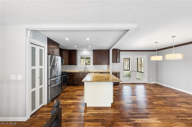 kitchen featuring dark brown cabinetry, decorative backsplash, french doors, stainless steel appliances, and a sink