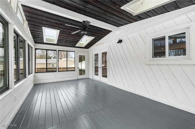 unfurnished sunroom with vaulted ceiling with skylight and a ceiling fan