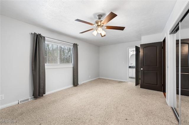 unfurnished bedroom featuring visible vents, baseboards, carpet floors, a closet, and a textured ceiling