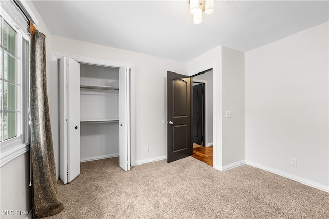 unfurnished bedroom featuring a closet, baseboards, and carpet