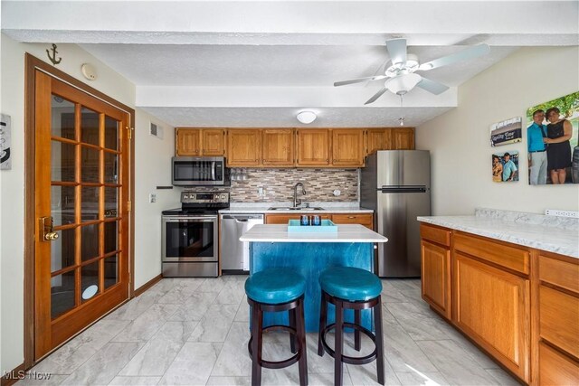 kitchen with visible vents, a sink, stainless steel appliances, light countertops, and marble finish floor