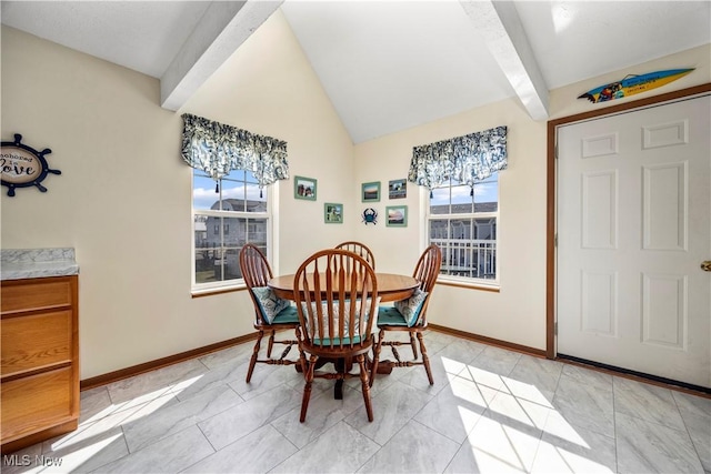 dining room featuring vaulted ceiling with beams and baseboards