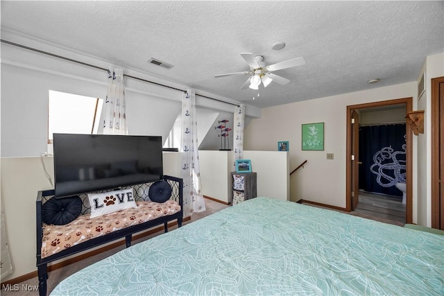 bedroom with ceiling fan, baseboards, visible vents, and a textured ceiling