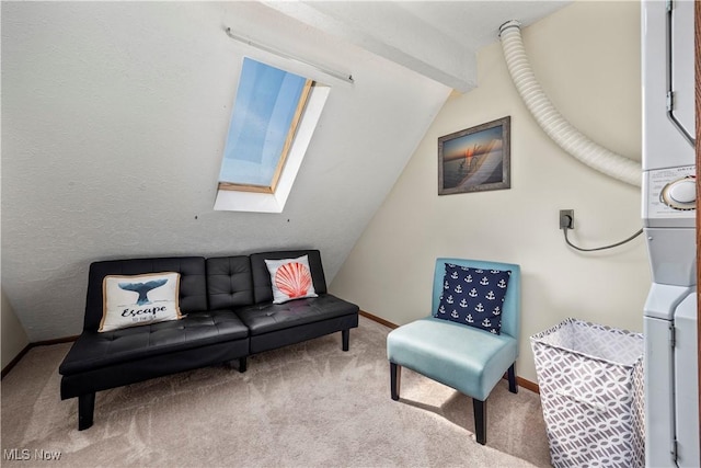 living area with baseboards, vaulted ceiling with skylight, and carpet flooring