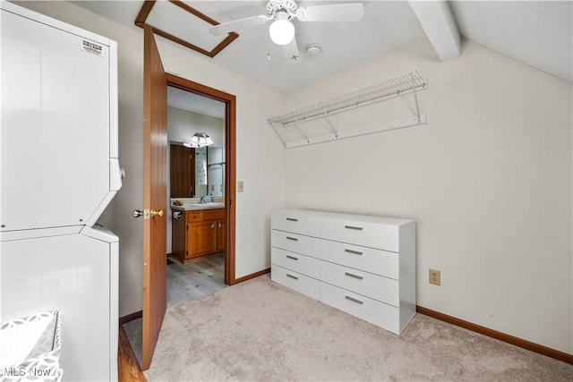 spacious closet with light carpet, a sink, a ceiling fan, and stacked washer and dryer