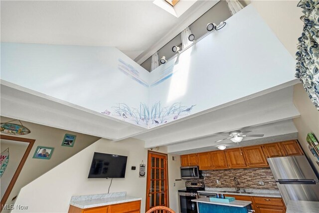 kitchen featuring a sink, decorative backsplash, light countertops, stainless steel appliances, and brown cabinets