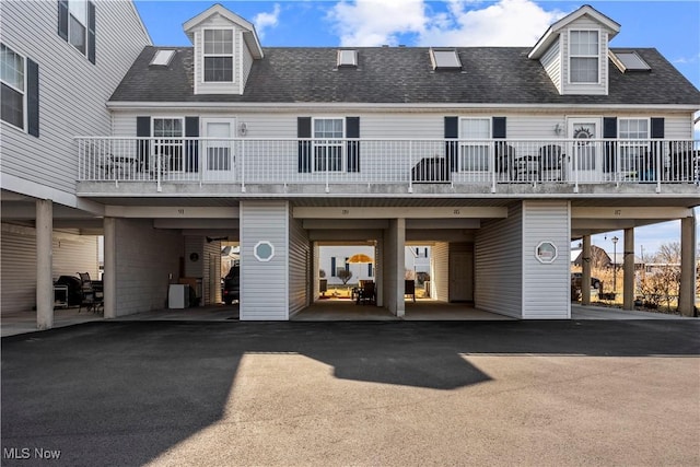 exterior space featuring a carport, driveway, and a shingled roof