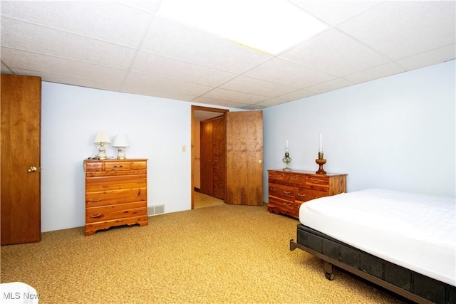 carpeted bedroom with visible vents and a paneled ceiling