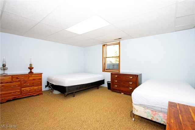 bedroom with light carpet and a drop ceiling