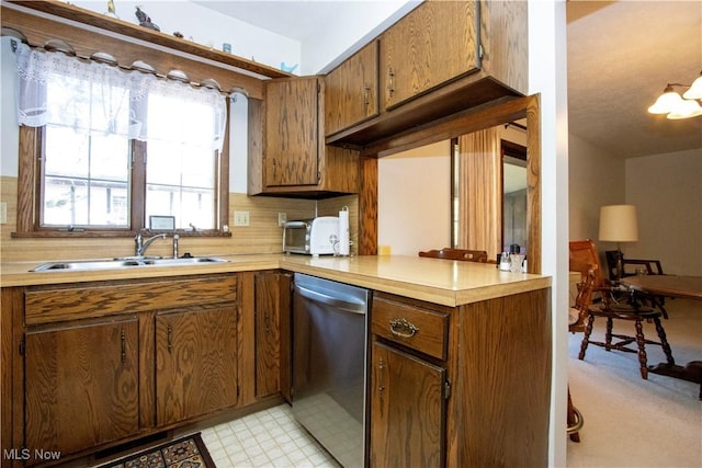 kitchen with a sink, tasteful backsplash, dishwasher, and light countertops