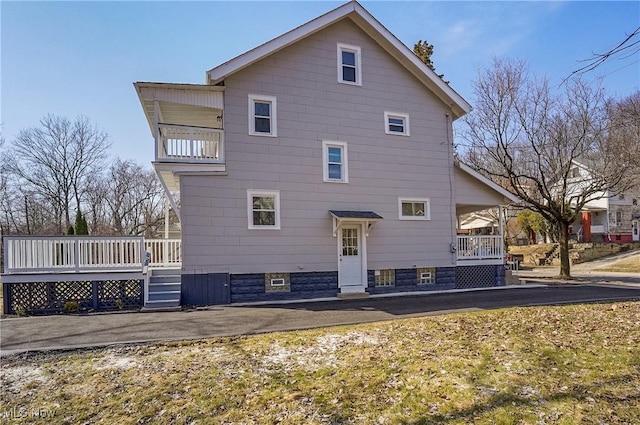 back of house featuring a wooden deck and a balcony