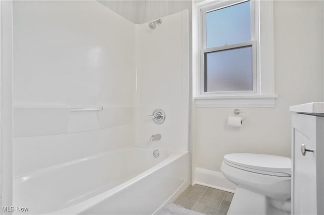 full bathroom with toilet, wood finished floors, shower / bath combination, baseboards, and vanity