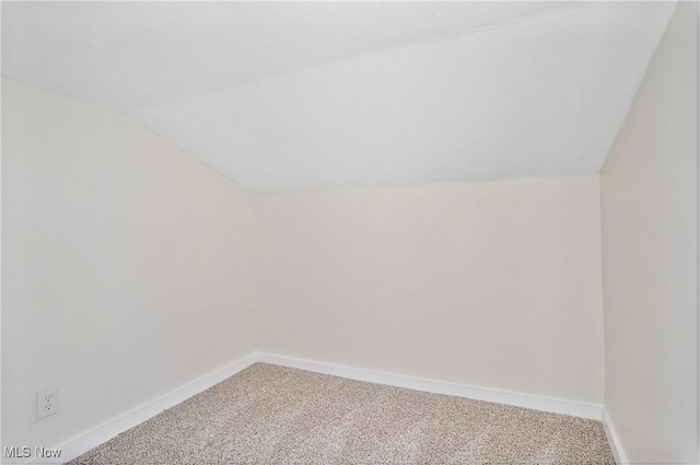 additional living space with carpet flooring, baseboards, and vaulted ceiling