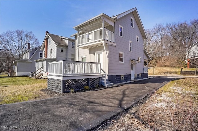 back of property featuring a yard and a balcony