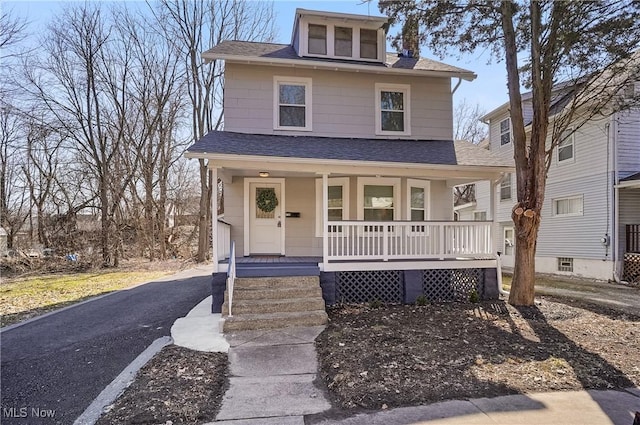 traditional style home with covered porch and a shingled roof