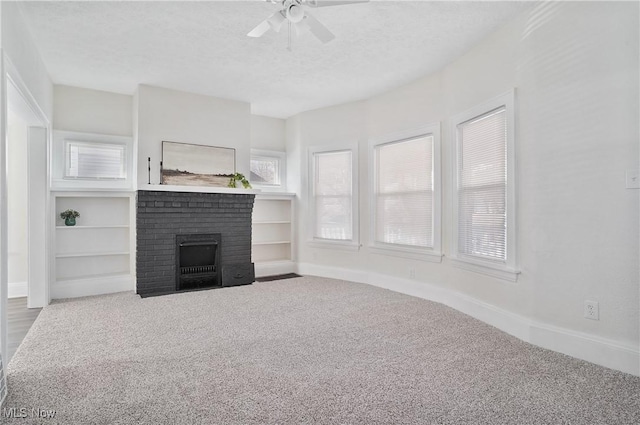 unfurnished living room featuring a fireplace, a textured ceiling, baseboards, and a ceiling fan