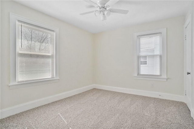 carpeted spare room featuring baseboards and ceiling fan