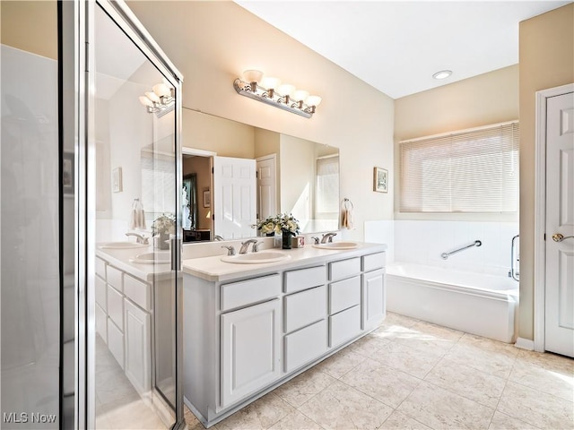 full bath featuring a sink, a bath, double vanity, and tile patterned flooring