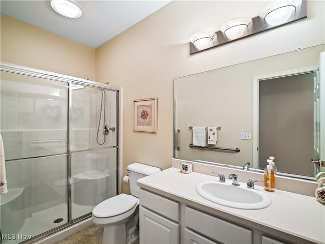 full bathroom featuring vanity, toilet, a stall shower, and tile patterned flooring