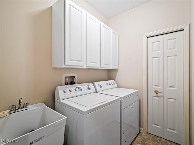 washroom with cabinet space, separate washer and dryer, and a sink