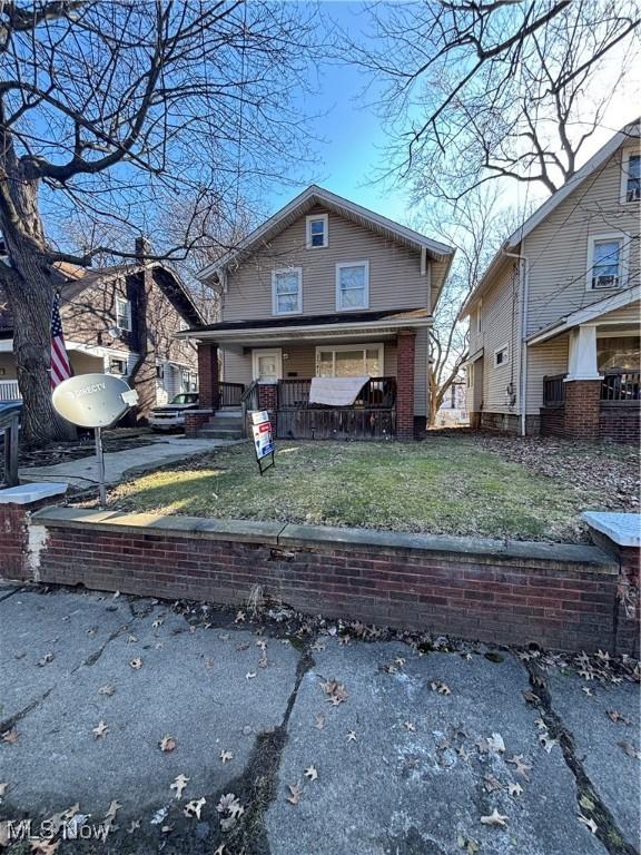 view of front of home with a porch and a front lawn