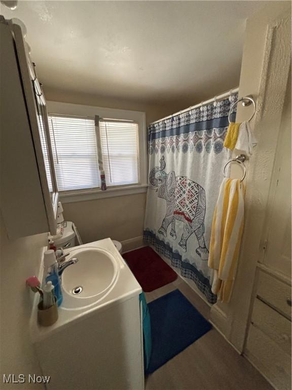 bathroom with vanity, a shower with shower curtain, and baseboards