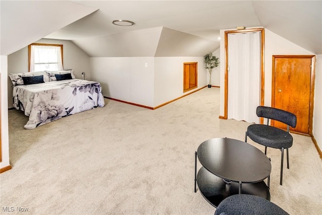 bedroom featuring vaulted ceiling, light colored carpet, and baseboards