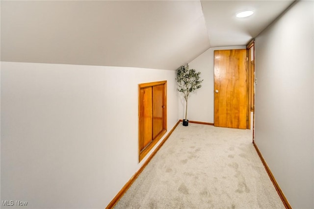 additional living space featuring lofted ceiling, baseboards, and light carpet