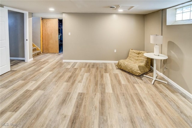 unfurnished room featuring light wood finished floors, stairway, and baseboards