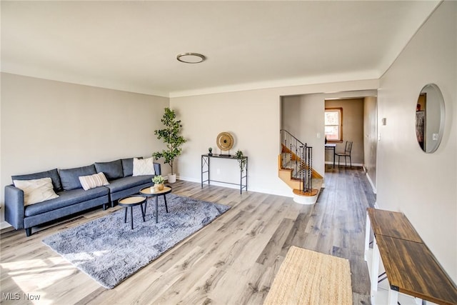 living room with stairs and wood finished floors