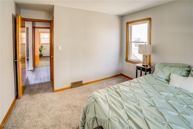 carpeted bedroom featuring visible vents and baseboards