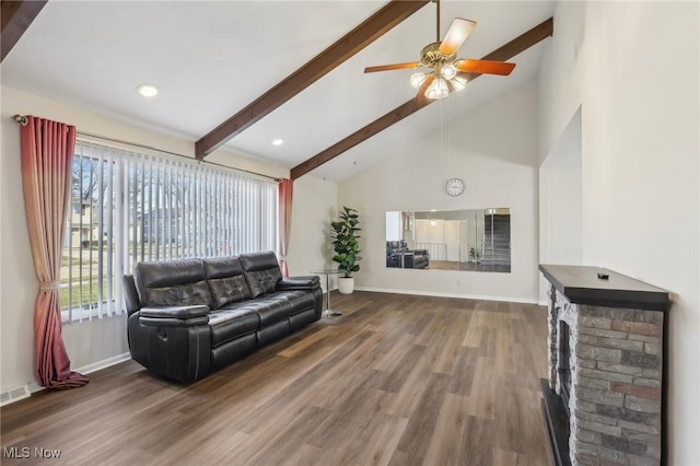 living area with beam ceiling, high vaulted ceiling, baseboards, and wood finished floors