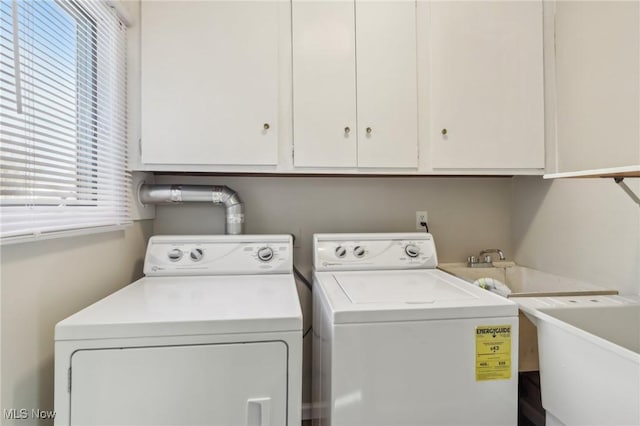 washroom featuring a sink, cabinet space, and separate washer and dryer