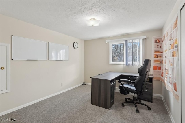 home office featuring baseboards, carpet floors, and a textured ceiling