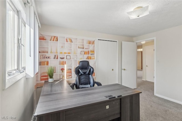 office with carpet flooring, a wealth of natural light, and a textured ceiling