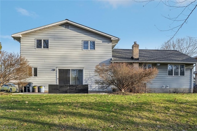 rear view of house featuring a lawn and a chimney