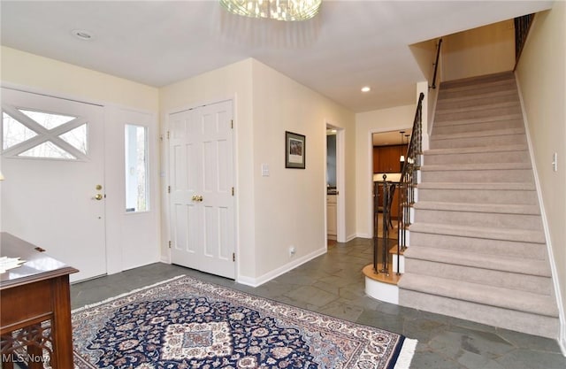 foyer entrance with stairway, recessed lighting, and baseboards