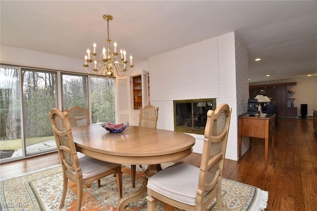 dining room with recessed lighting, a large fireplace, and hardwood / wood-style floors