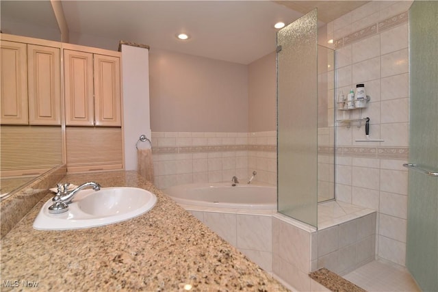 full bathroom featuring a sink, a garden tub, recessed lighting, and a tile shower