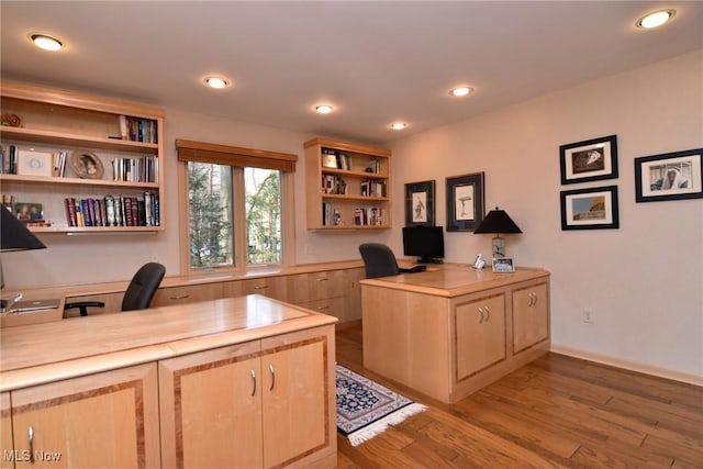 home office featuring recessed lighting, built in study area, and light wood-type flooring