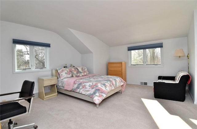 bedroom featuring vaulted ceiling, carpet flooring, and visible vents