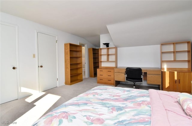 bedroom featuring lofted ceiling and light colored carpet