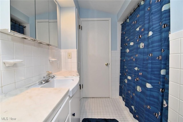 full bath with tile patterned floors, curtained shower, tile walls, and vanity