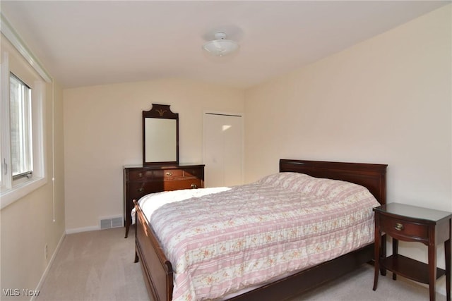 bedroom with light colored carpet, visible vents, and baseboards