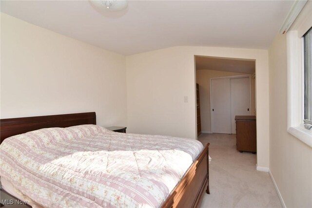 bedroom with light colored carpet and baseboards