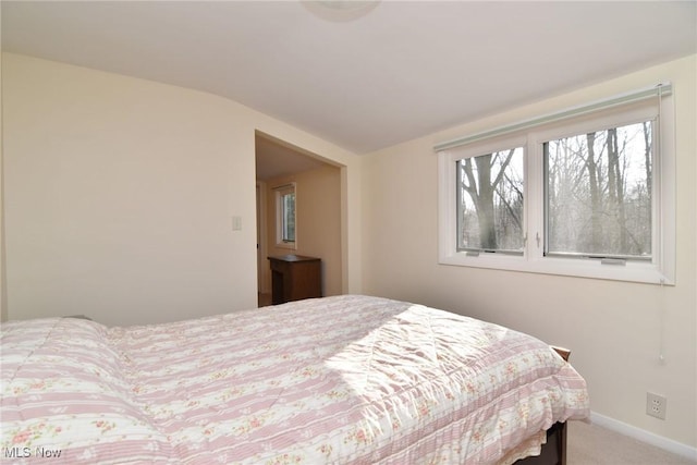 bedroom with light colored carpet and baseboards