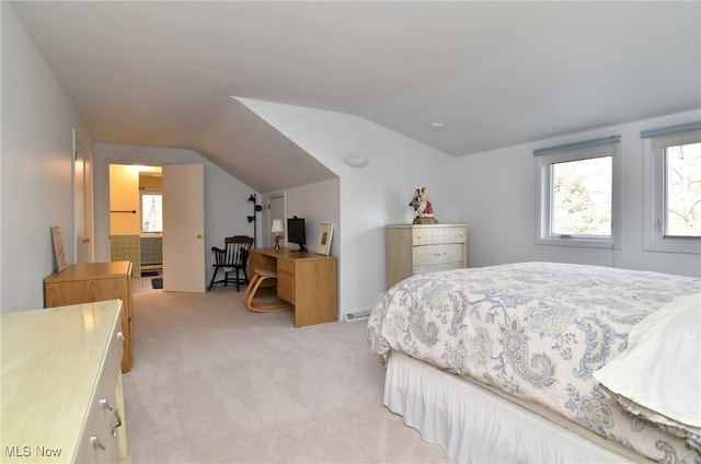 bedroom featuring light carpet and vaulted ceiling