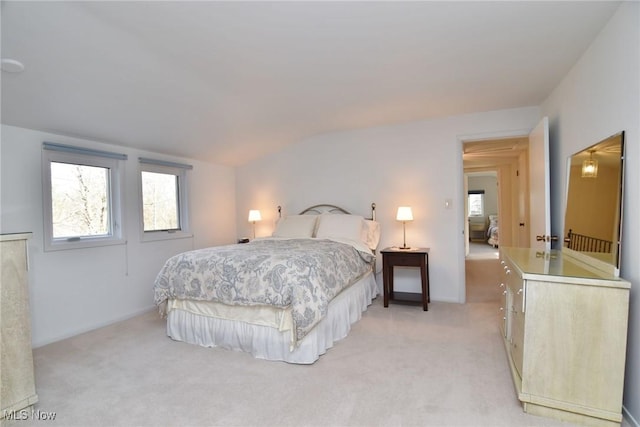 bedroom featuring vaulted ceiling and light colored carpet